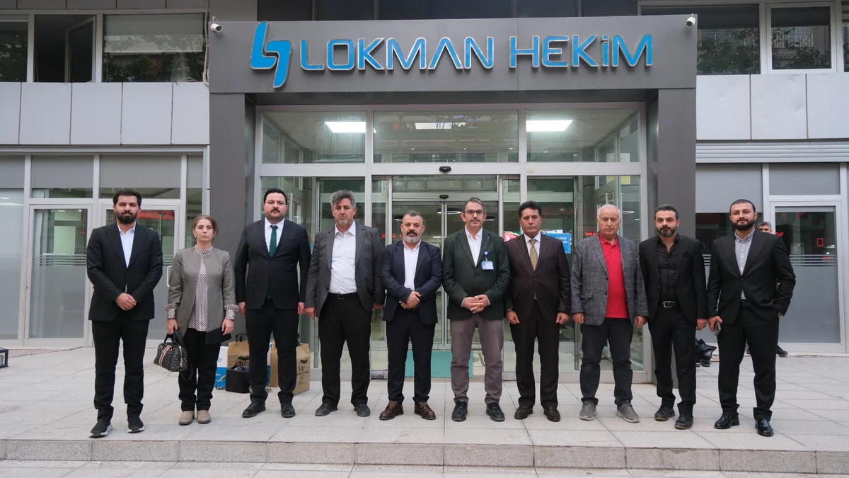 Kuzey Irak heyeti ve Lokman Hekim Van Hastanesi yöneticileri, hastanenin giriş kapısı önünde toplu fotoğraf çektiriyor.