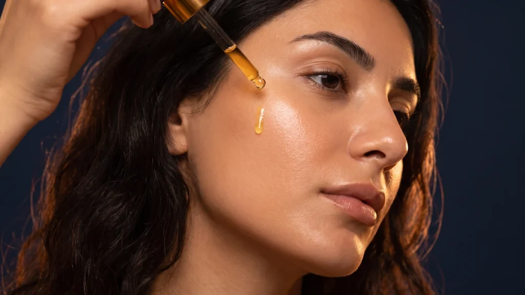 Yanağına retinol serumu damlatan kadın
